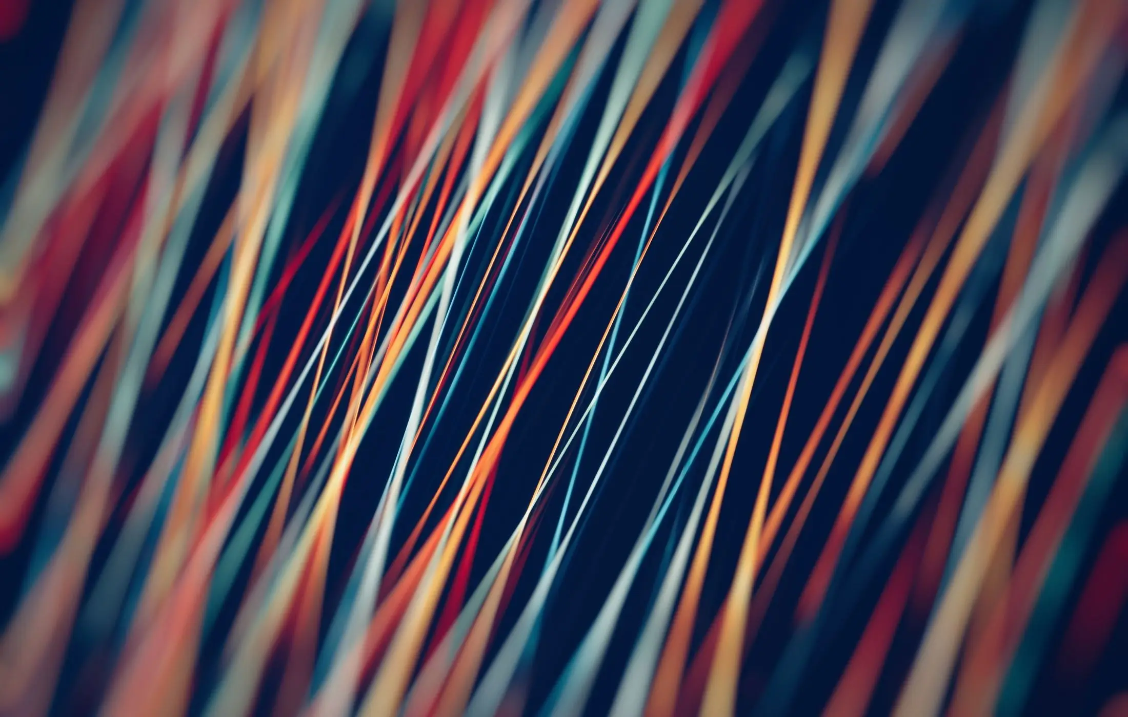 Abstract pattern of glowing, colorful lines crossing a dark background.